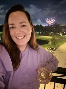 Solo traveler watching EPCOT fireworks from the balcony of a Tower Studio at Disney's Riviera Resort